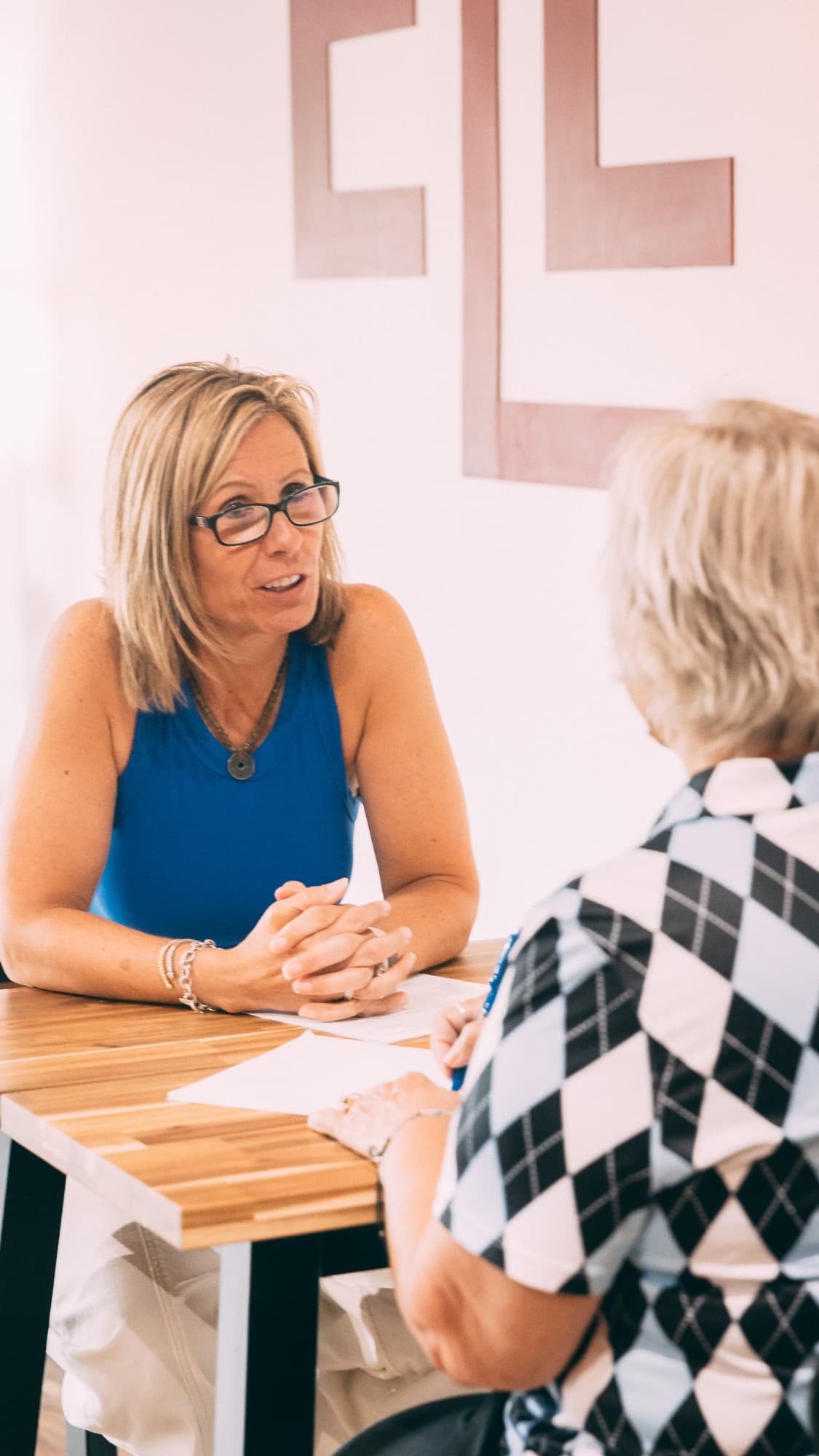 Elevate founder Jaime Hughes leaning in during a one-on-one consultation with a client at the studio